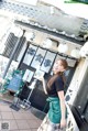 A woman standing in front of a restaurant holding a menu.