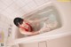 A woman in a red bathing suit is taking a bath.