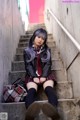 A woman sitting on the steps of a building.