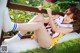 A woman in a cheerleading uniform is sitting on a bench.